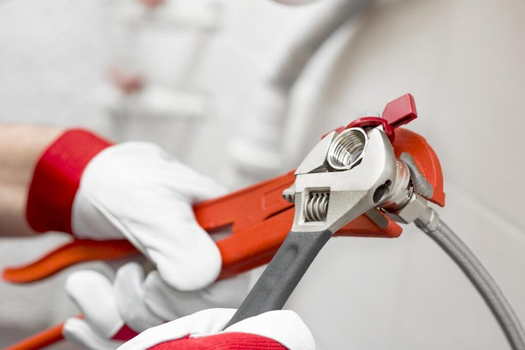 Plumber holding pipe wrenches for an emergency repair in Lebanon